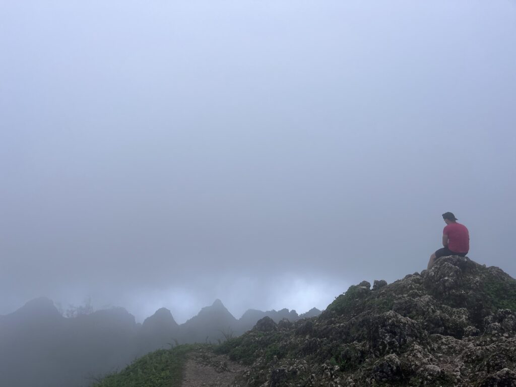 Rhys Alexander Sain sitting at the top of Osmeña Peak, Cebu, Philippines
